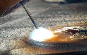 What is the function of flux in arc welding